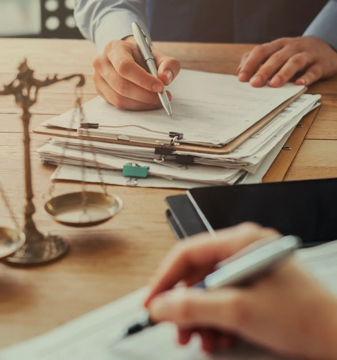 Lawyer signing documents with scales of justice